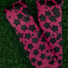 Black and pink patterned leg warmers on grass