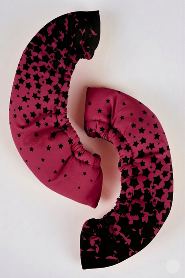 Pink and black patterned travel pillow on a white background