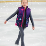 Junior figure skater wearing vest on ice rink